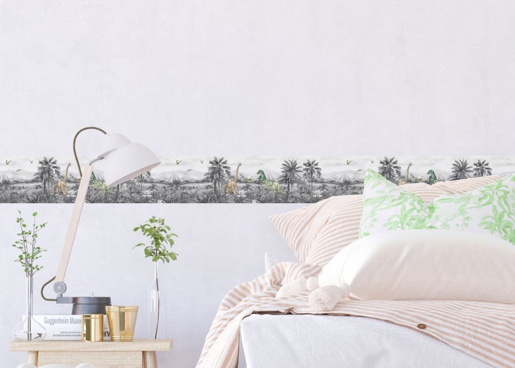 Dekorierter Raum mit Bordüre mit Dinosaurier-Motiv, Nachttischlampe und Bett
