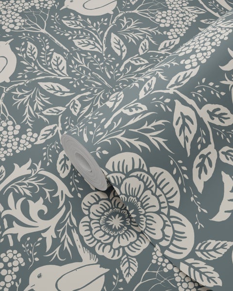 Vliestapete mit floralem Muster aus großen Blüten, Blättern und Vögeln, eine Rolle teilweise ausgerollt.