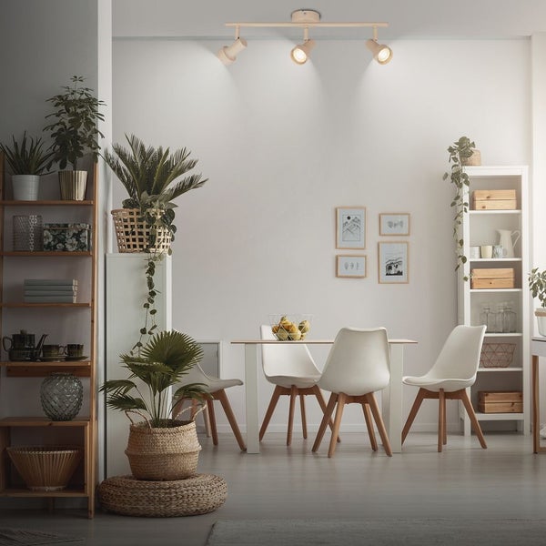 Helles, modernes Esszimmer mit dreiflammiger Deckenleuchte, weißem Esstisch, vier Stühlen, Holzregalen und zahlreichen Zimmerpflanzen.