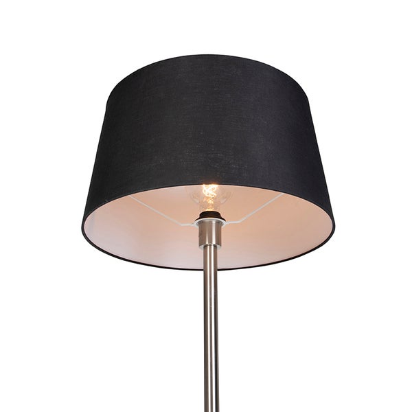 Stehleuchte mit schwarzem Textilschirm und silbernem Metallstativ, Detailansicht mit brennendem Leuchtmittel.