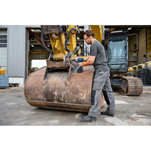 Ein Mann verwendet einen Akku-Drehschlagschrauber an einem Bagger.