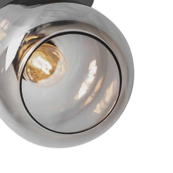 Nahaufnahme eines kugelförmigen Lampenschirms aus Glas mit einem Leuchtmittel im Inneren.