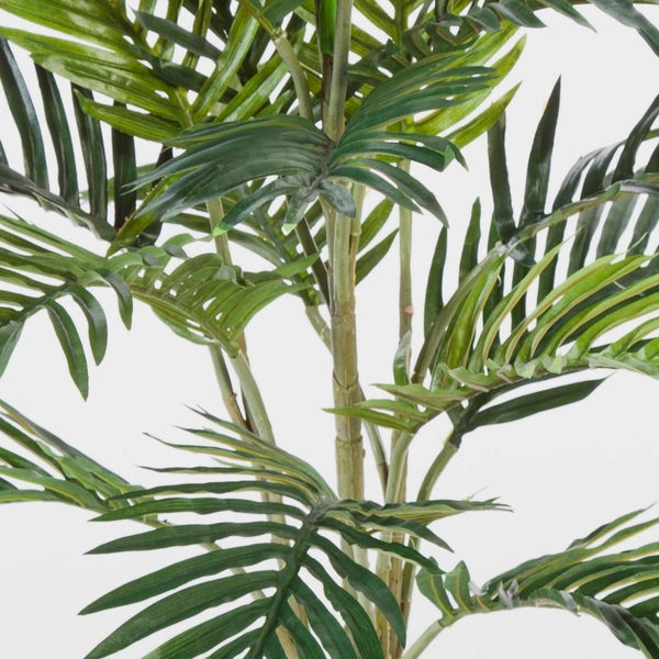 Künstliche Palme mit detailreichen grünen Palmwedeln.