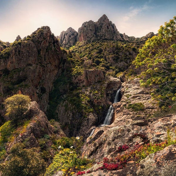 Landschaft mit Felsen, Vegetation und Wasserfällen