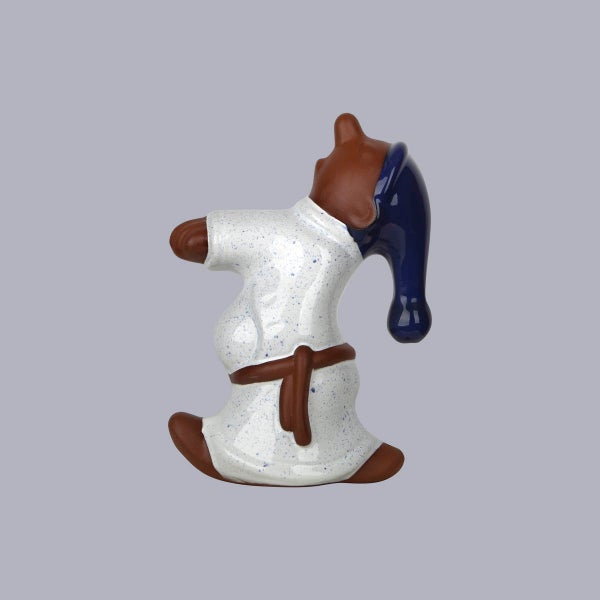 Dekofigur gähnendes Sandmännchen aus Keramik mit weißem Nachthemd und blauer Schlafmütze.