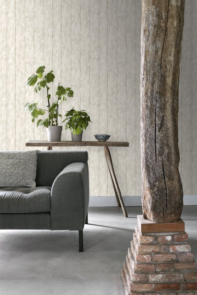 Wohnzimmer mit grauer Couch, Holztisch, Pflanzen und strukturierten Tapeten