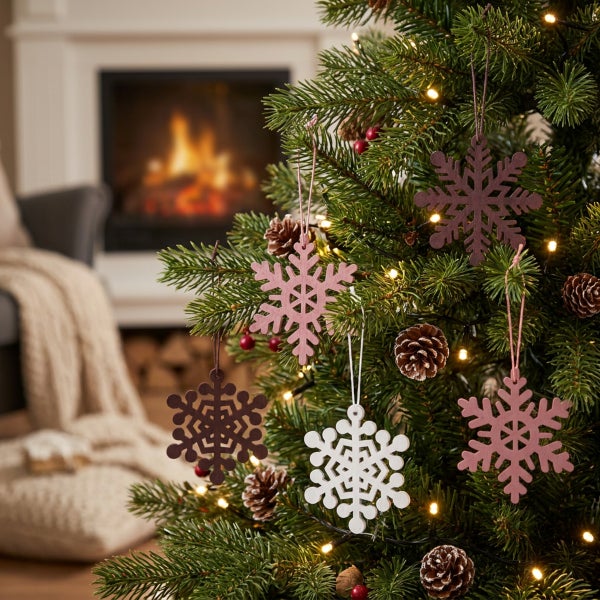 Holz Schneeflocken Anhänger für den Weihnachtsbaum vor einem Kamin in einem gemütlich eingerichteten Raum