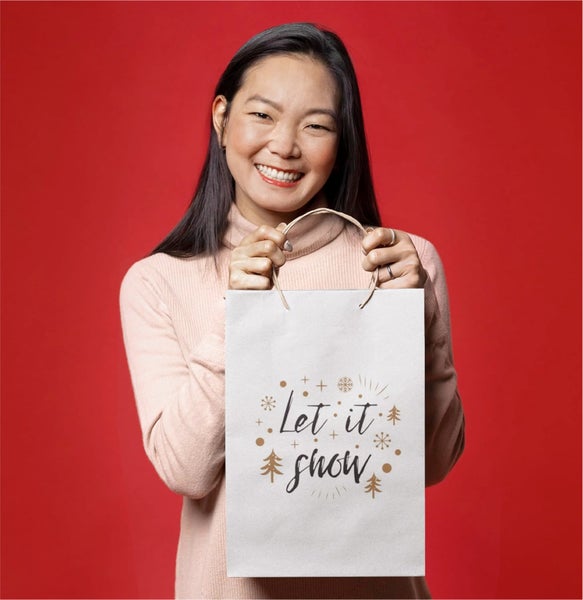 Frau hält Papiertragetasche mit dem Schriftzug Let it Show.