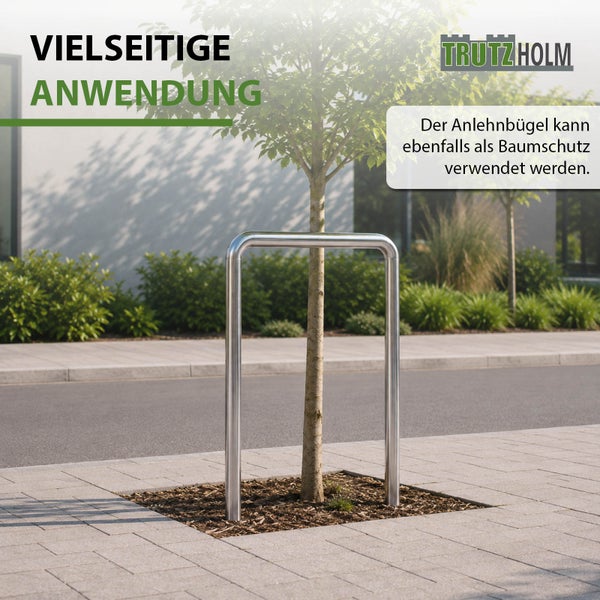 Trutzholm Anlehnbügel aus Metall als Baumschutz in einem Außenbereich mit Pflaster und einem jungen Baum installiert.