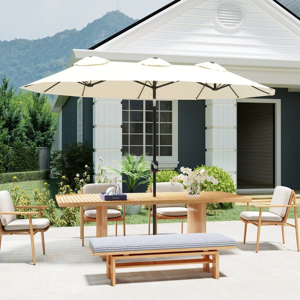 Großer Doppelsonnenschirm über einem hölzernen Gartentisch mit Bank und Stühlen auf einer Terrasse vor einem Haus.