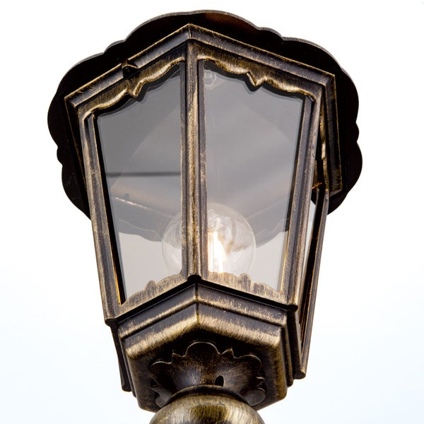 Außenleuchte in Laternenform im antiken Stil aus Metall mit klarem Glas, sichtbarem Leuchtmittel und gold-schwarzer Patina.