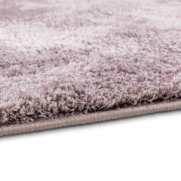 Detailansicht eines Hochflor-Teppichs mit geketteltem Rand und melierter Textur.
