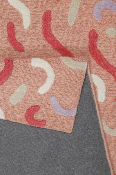 Kurzflor-Teppich mit abstraktem Muster aus geschwungenen Formen, umgeschlagene Ecke zeigt graue Rückseite.