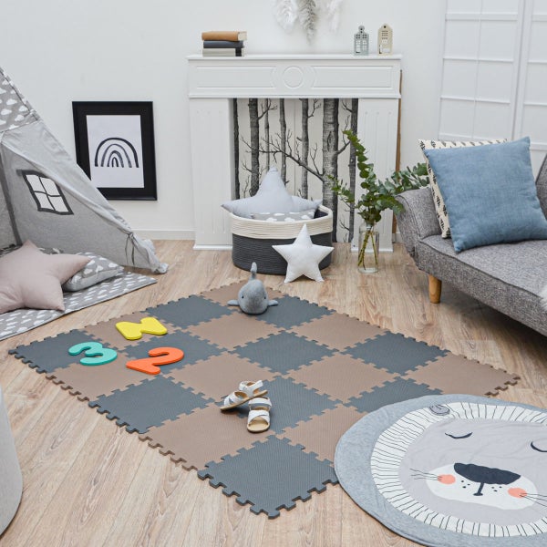 Hell eingerichteter Kinderspielbereich mit Schaumstoff-Puzzlematte in Schachbrettoptik, grauem Tipi-Zelt, Sofa und Dekokissen auf Holzboden.