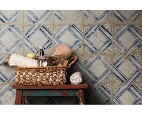 Badezimmerstillleben mit gemusterten Fliesen und Badutensilien in einem Korb