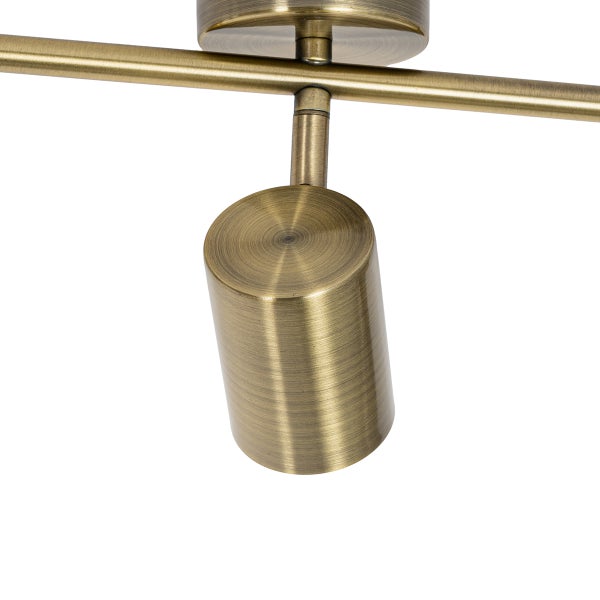 Detailaufnahme einer Deckenschiene mit einem einzelnen schwenkbaren Strahler in Messingoptik.