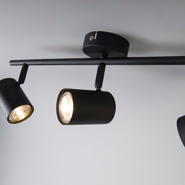 Schwarze Deckenleuchte mit mehreren Strahlern.