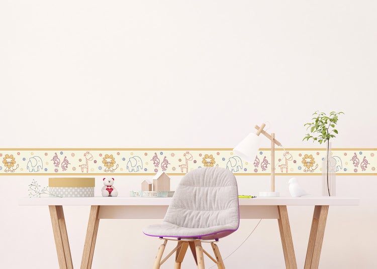 Tapetenbordüre mit Tiermotiven in einem hellen Kinderzimmer, angebracht an der Wand über einem Schreibtisch mit Arbeitsstuhl.