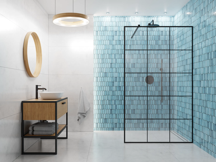 Modernes Badezimmer mit begehbarer Dusche, schwarzer Glaswand, blauen Fliesen, Holz-Waschtisch, rundem Spiegel und runder LED-Deckenleuchte.