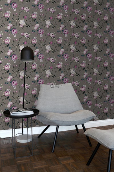 Dekoratives Wohnzimmer mit Blumentapete, Leuchte, Tisch und Stuhl.