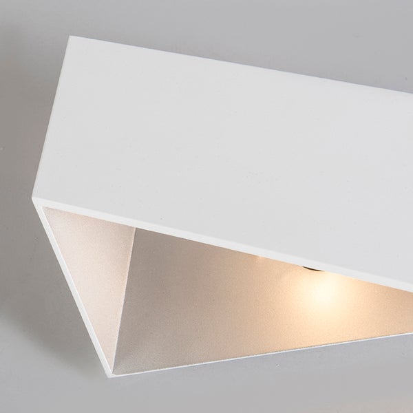 Moderne rechteckige Wandleuchte mit warmweißem Licht in einer dreieckigen Aussparung.