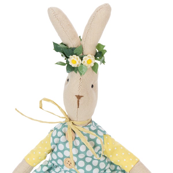 Dekorativer Osterhase aus Stoff mit grün gepunktetem Kleid und Blumenkranz.