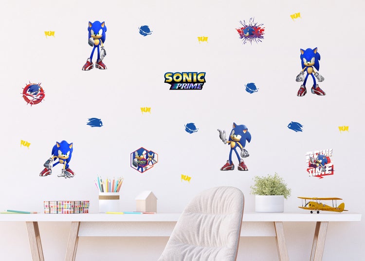Sonic Prime Wandsticker mit Charakterposen und Sonic Prime Logo über einem Schreibtisch mit Schreibutensilien und Spielzeugflugzeug.
