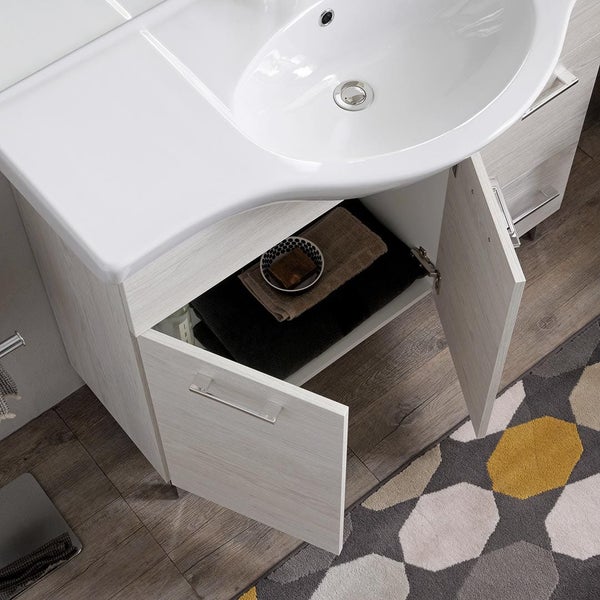 Waschbecken mit Unterschrank in Holzoptik, geöffnete Türen mit Handtüchern im Inneren, auf Holzboden neben einem gemusterten Teppich.