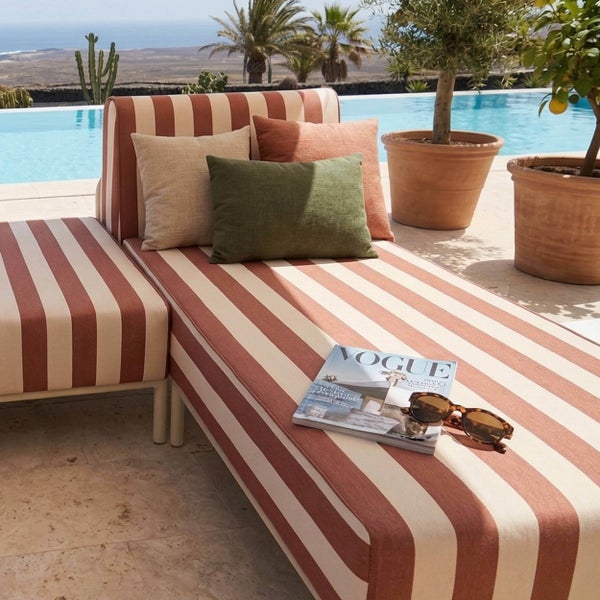 Modulare Gartenlounge bestehend aus zwei Liegeelementen mit gestreiftem Bezug und Metallgestell.