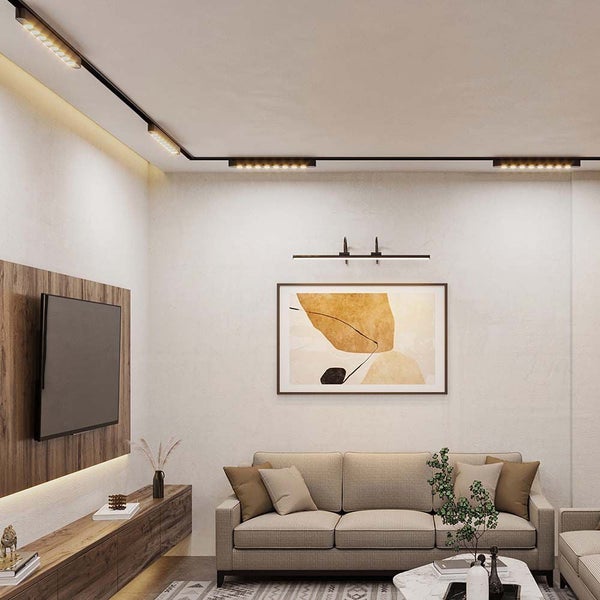 Wohnzimmer mit Schienensystembeleuchtung, Couch und Fernsehwand