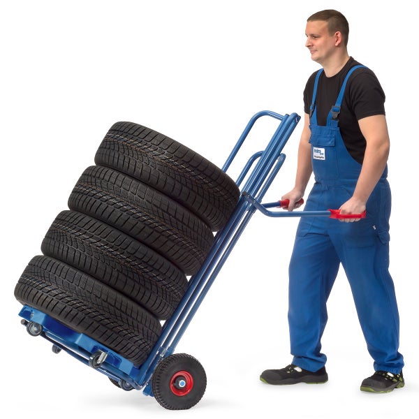 Eine Person transportiert Reifen auf einer Sackkarre.