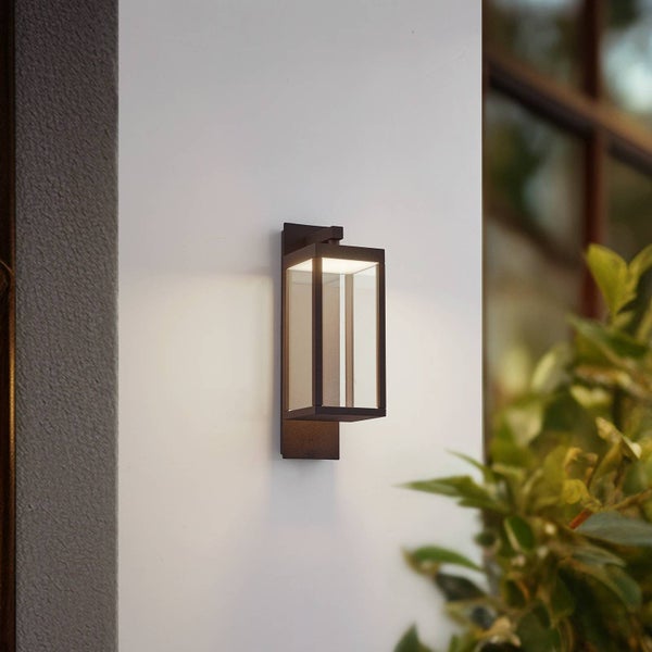 Moderne, rechteckige Außenwandleuchte mit schwarzem Rahmen und klarem Glas, montiert an einer Wand im Außenbereich.