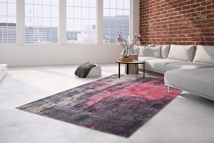 Wohnzimmer mit modernem Design und einem rechteckigen Teppich mit abstraktem Muster in einer hellen Loft Wohnung mit Backsteinwand.