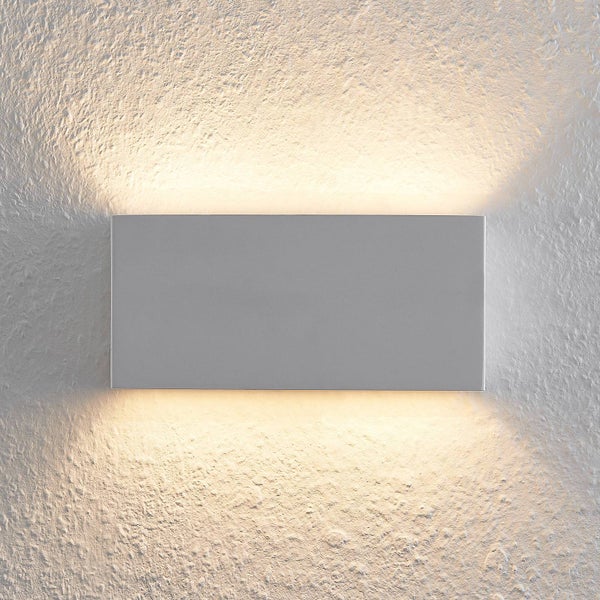 Rechteckige graue Wandleuchte an strukturierter Wand mit Lichtaustritt nach oben und unten.