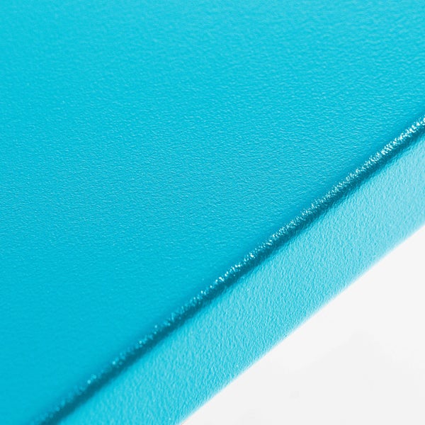 Nahaufnahme einer fein strukturierten blauen Oberfläche mit abgerundeter Kante.