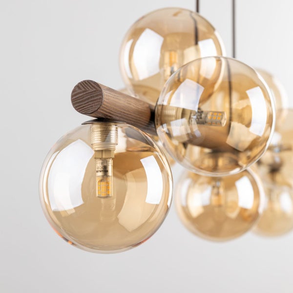 Deckenleuchte mit Holzbalken und bernsteinfarbenen Kugeln