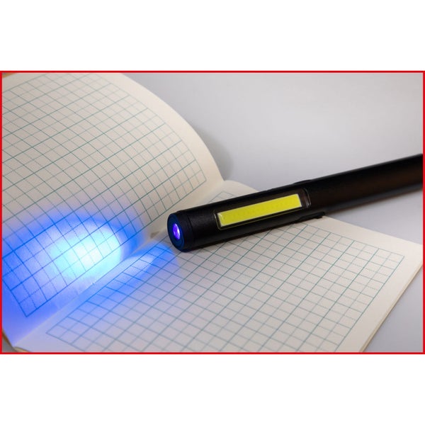 Stiftlampe mit Ultraviolettlicht auf einem Notizbuch