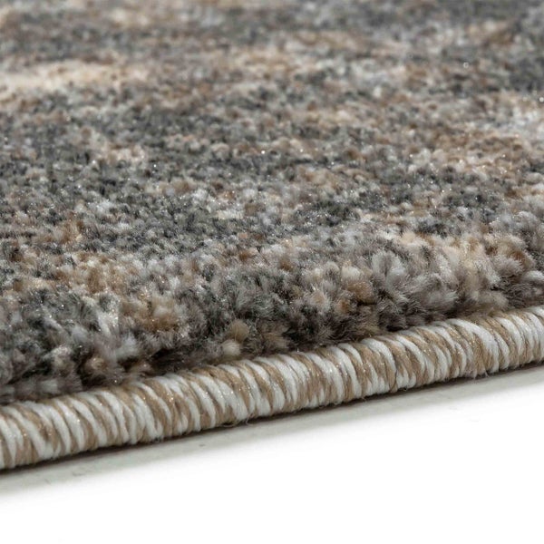 Nahaufnahme eines Hochflor-Teppichs in Grau- und Brauntönen mit gekettelter Kante.