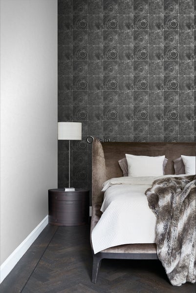 Schlafzimmer mit gemusterter Tapete, Nachttisch und Bett