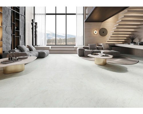 Heller Wohnraum mit Fliesenboden, Sofas, Tisch und Treppe