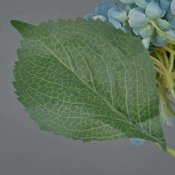 Detailansicht eines grünen Blattes einer künstlichen Hortensie mit sichtbarer Blattstruktur und gezacktem Rand.