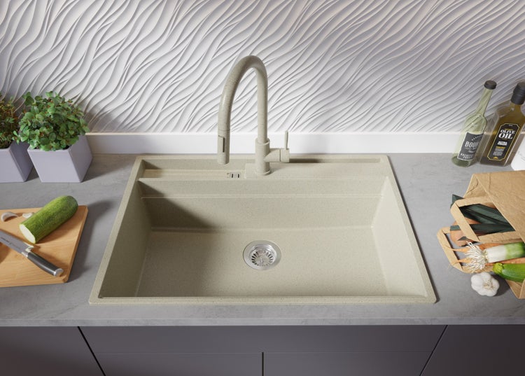 Küchenspüle mit Armatur auf Arbeitsplatte mit Gemüse und Ölflaschen