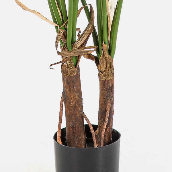 Künstliche Pflanze im schwarzen Topf mit naturgetreuen Stämmen und grünen Blättern.