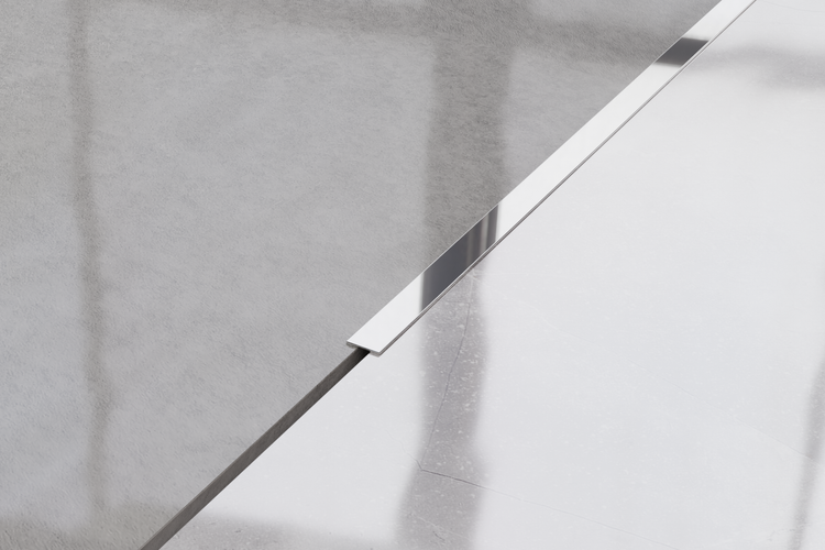 Detailaufnahme einer Duschrinne aus Metall im Badezimmer.