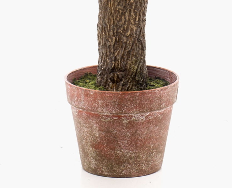 Künstliche Hängepflanze mit langen schmalen grünen Kunststoffblättern in Nahaufnahme.