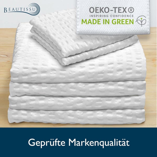 Stapel weißer Textilien mit Waffelstruktur, Beautissu Logo und Oeko-Tex Made in Green Siegel.