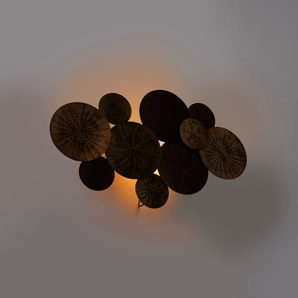 Dekorative Wandleuchte mit kreisförmigen Metallelementen für stimmungsvolle Beleuchtung