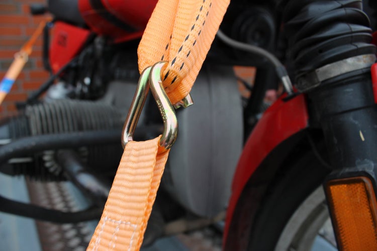 Detailansicht eines Motorrads, gesichert mit einem Spanngurt mit Haken