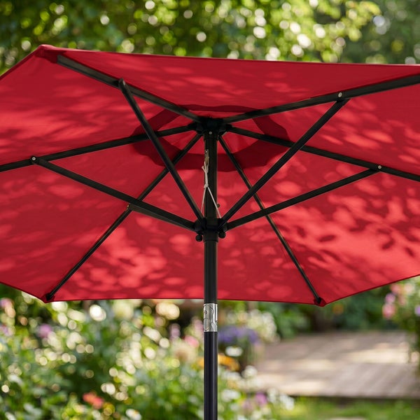Roter Sonnenschirm mit schwarzem Metallgestänge, Unteransicht im sonnigen Garten.