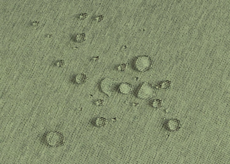 Nahaufnahme eines wasserabweisenden Stoffes mit Wassertropfen